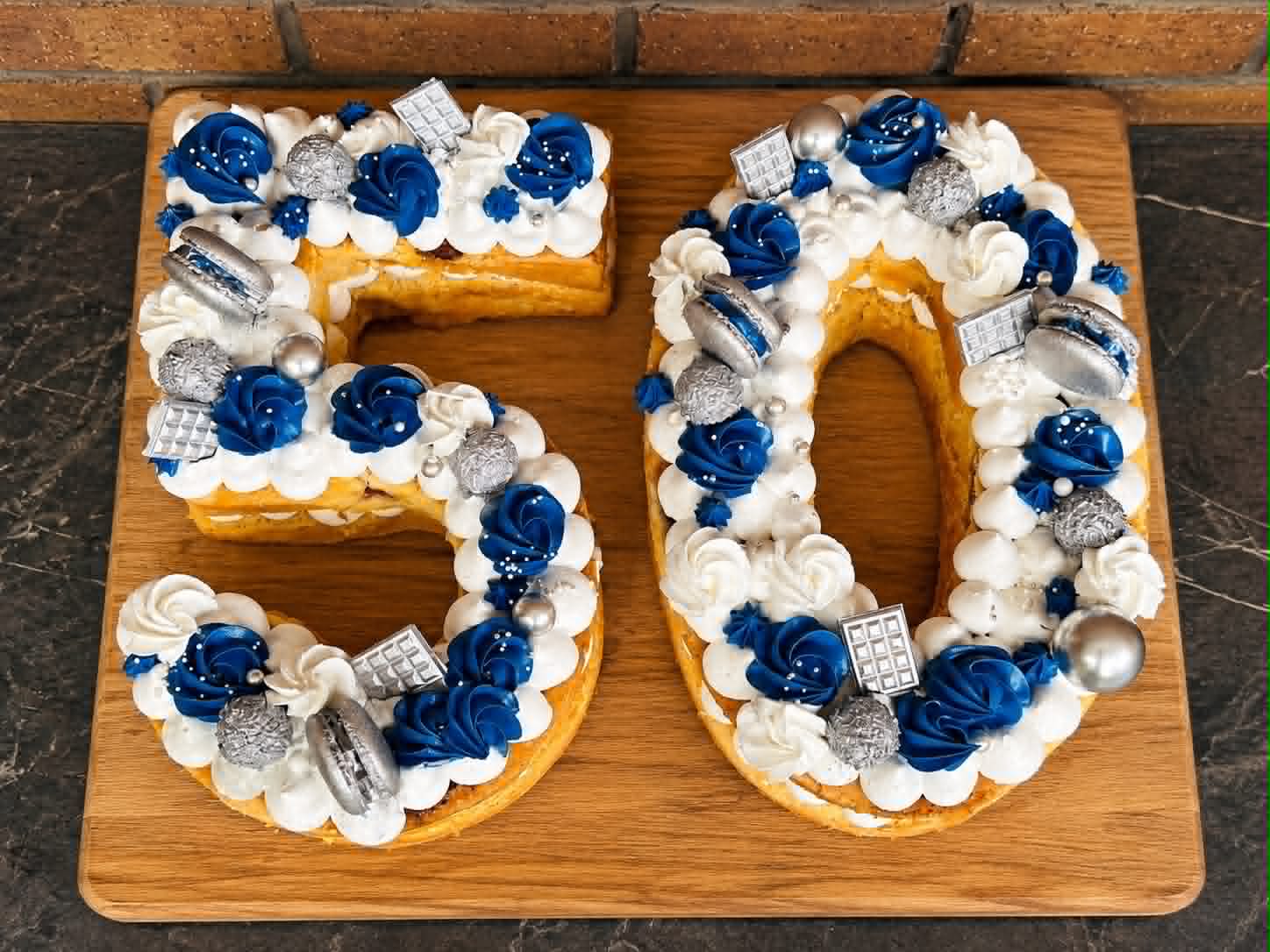Number 50 shaped cake with blue roses, silver decorations and cream filling